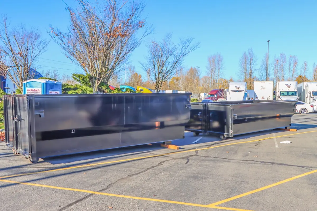 Professional dumpster rental service with roll-off container on residential driveway in Belmar